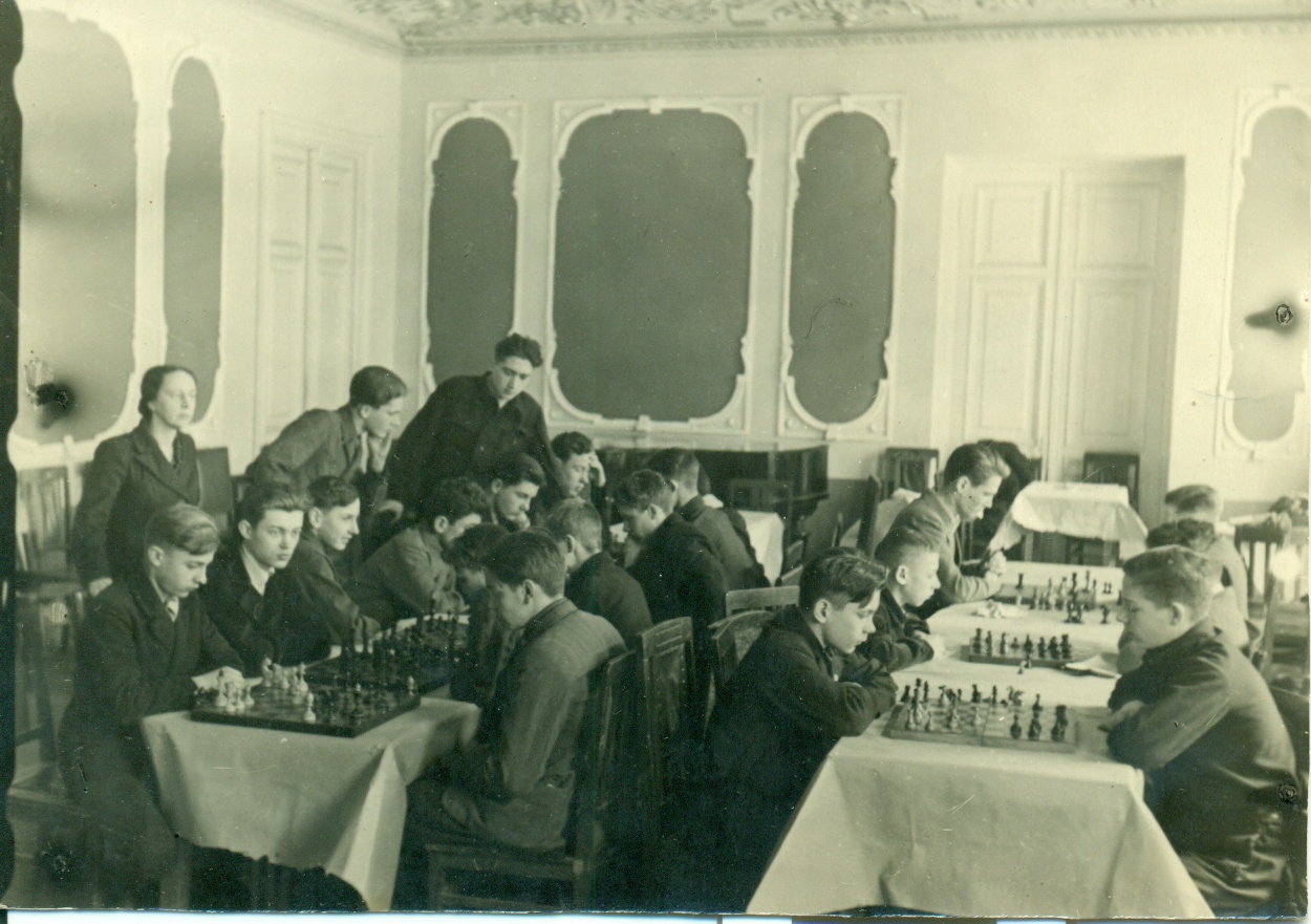 Шахматный кружок Дома пионеров Красногвардейского района Москвы, 1950 - 1960, г. Москва. Призер первых чемпионатов СССР по шахматам среди женщин Ольга Вячеславовна Морачевская руководит занятием шахматного кружка. Дом пионеров помещался во дворце Апраксиных-Трубецких у Покровских ворот.Фотография из архива Андрея Гришина.