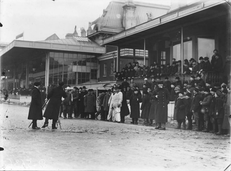 Фотограф снимает зрителей на плацу, наблюдающих за бегами, 1912 год