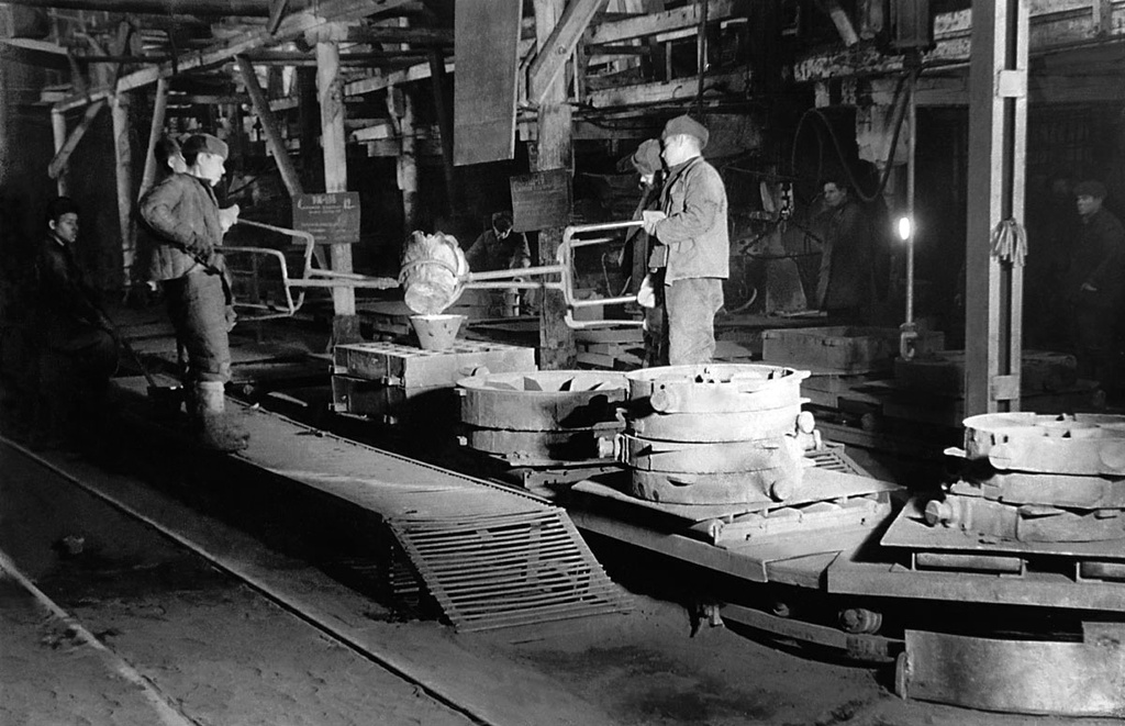 Металлургический завод. Заливка металла в формы, 1940-е, Челябинская обл.. За годы войны произошло наращивание мощностей в черной металлургии. Было построено шесть доменных печей, 28 сталеплавильных и электрических печей, пять коксовых батарей, пять прокатных и три трубопрокатных стана.&nbsp;В послевоенные годы восемь заводов области перешли к экономичным методам литья (в том числе и литье по выплавляемым моделям), но это составляло лишь доли процента всего металлургического производства. Переход к новым формам экономичного литья пришелся на 5-ю пятилетку (1951–1955).&nbsp;