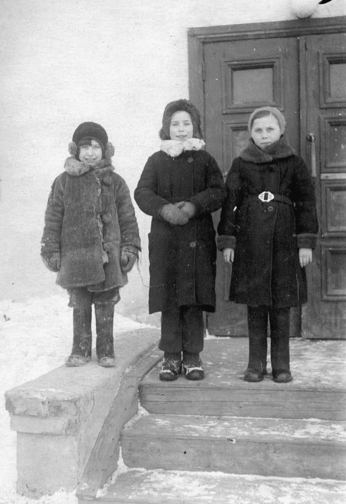 Дети у дома во дворе, 1942 - 1943, г. Москва. В центре – Тамара Обручникова. Снимок сделан на 7-й Парковой улице, которая получила свое название 18 ноября 1949 года как одна из 16 номерных Парковых улиц. Выставка «Нам не страшны мороз и вьюга» с этой фотографией.