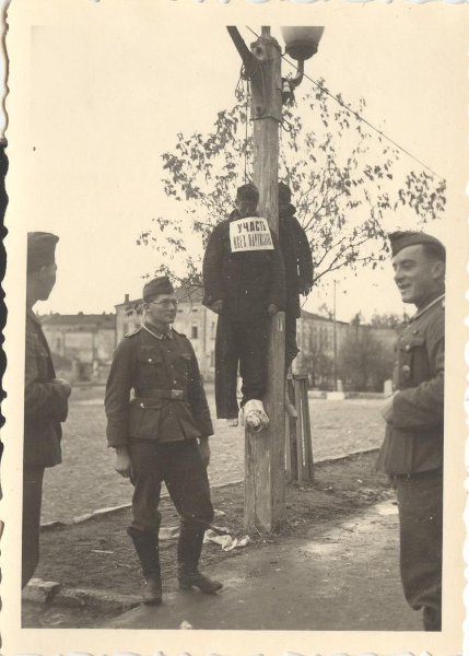 Около повешенных, октябрь 1941, г. Калуга. Табличка: «Участь всех партизан».
