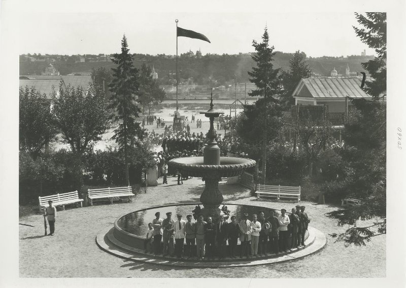 Открытие Всесоюзного торжища в Нижнем Новгороде – 3-й советской Нижегородской ярмарки, 1 августа 1924, г. Нижний Новгород. Поднятие флага в честь открытия. Участники фотографируются у фонтана.Видео «Три тысячи лавок. Нижегородская ярмарка» с этой фотографией.