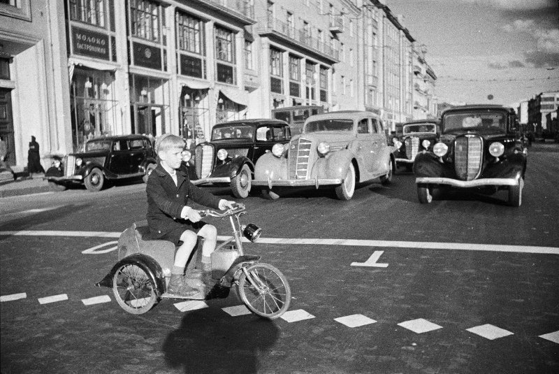 Мальчик на трицикле пересекает улицу Горького, 1935 год, г. Москва. Выставка «Скорость, драйв, мотоцикл – снято!» с этой фотографией.&nbsp;