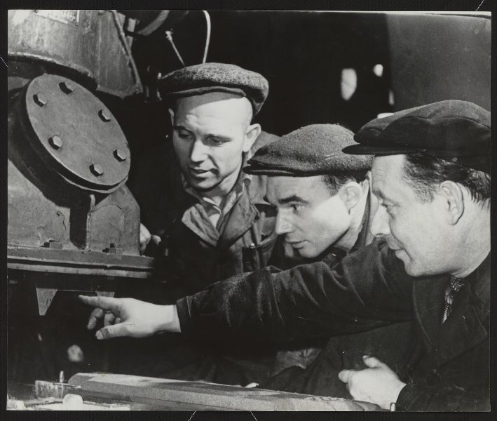 Кировский завод, 1937 год, г. Ленинград. «Члены постоянно действующего производственного совещания новочугунного цеха осматривают модернизированную силами рабочих цеха пескодувную машину, которая позволила поднять производительности труда более чем в два раза».