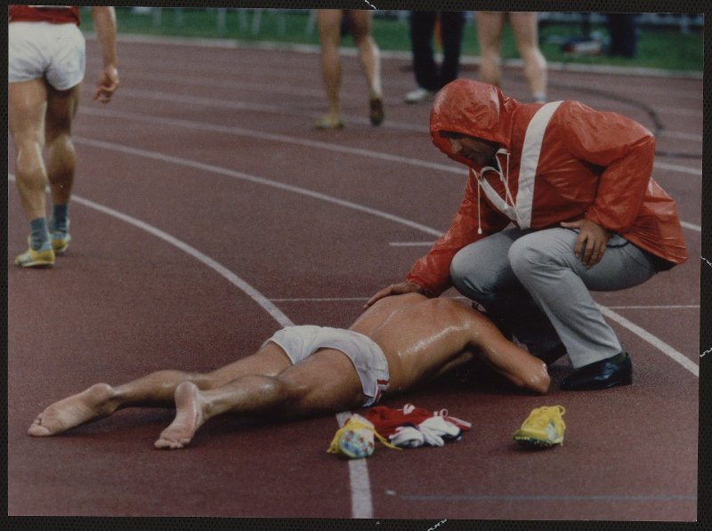 Спортсмен лежит на беговой дорожке, 1980-е. Выставка «Спортсмены. Сила духа и тела» с этой фотографией.