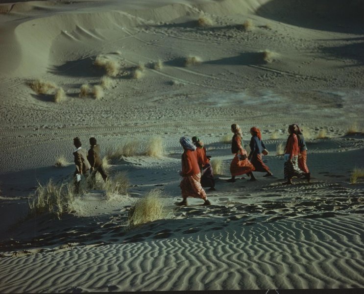 Группа людей, идущих по пустыне, 1980-е. Выставка «В пустыне» с этой фотографией.