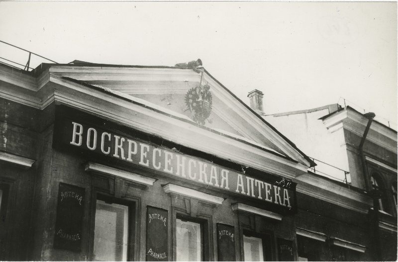 Воскресенская аптека. Снятие царских гербов, март 1917, г. Петроград. После Февральского переворота начался массовый отказ от монархической символики: повсеместно снимали царские гербы, переименовывали города, корабли и учреждения. В армии стали обращаться не «превосходительство», «высокопревосходительство», а «господин полковник» и «господин поручик». Подробнее о событиях после Февральского переворота смотрите здесь.Видео «Керенский. Навсегда виноватый» и выставка «Аптеки ХХ века» с этой фотографией.