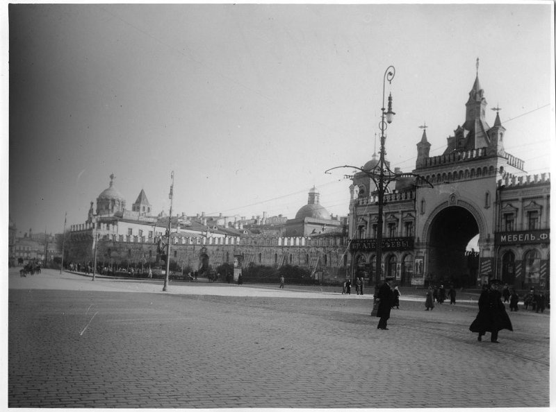 Театральный проезд, 1910 - 1916, г. Москва. Справа – арка-въезд Третьяковского проезда и Китайгородская стена. Проезд был построен в 1870-х годах братьями-меценатами Третьяковыми. В Китайгородской стене была прорублена арка. Справа на втором плане – часовня Пантелеймона Целителя, снесена в 1934 году.&nbsp;