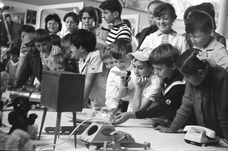 Дети и взрослые в Политехническом музее, 25 июля 1974 - 25 августа 1974, г. Москва. Выставка игрушек «Дети и техника», организованная Главным управлением по производству игрушек Министерства легкой промышленности СССР. В четырех залах Политехнического музея, где была размещена выставка, показано более 3000 различных игрушек.Выставка «СССР в 1974 году» с этой фотографией.