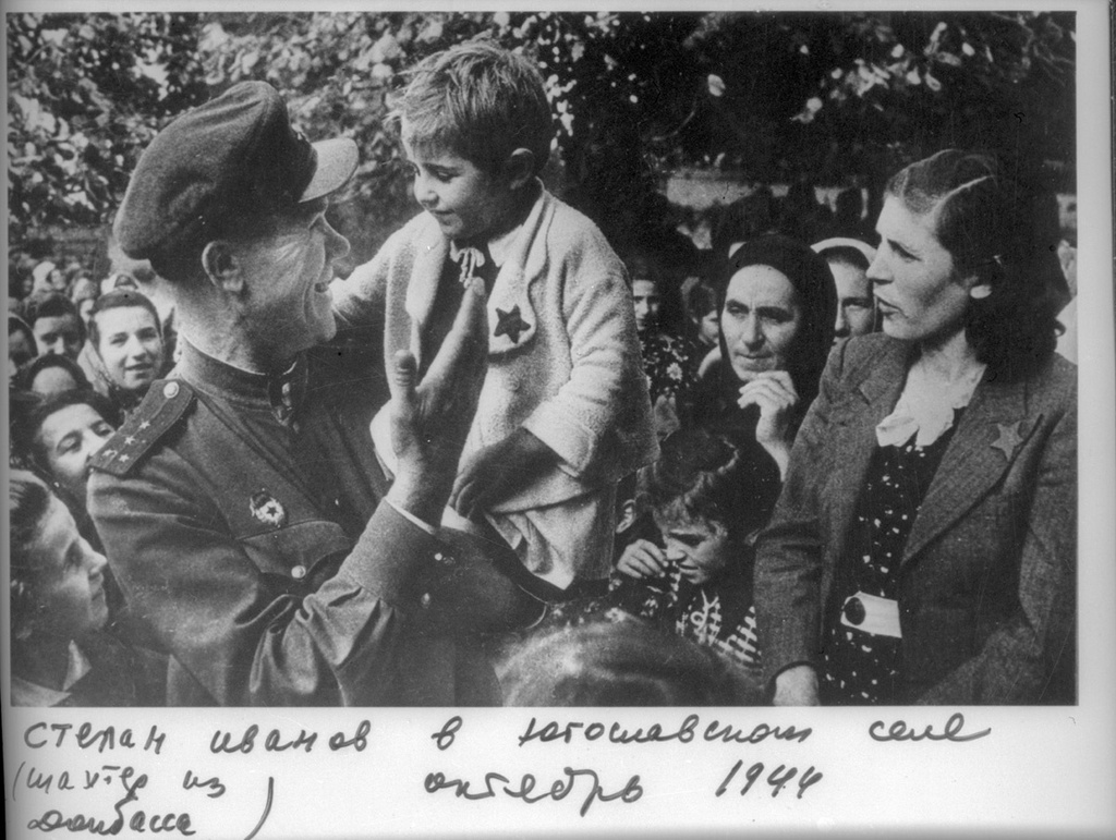 Степан Иванов, шахтер из Донбасса, в югославском селе с девочкой на руках, октябрь 1944, Югославия