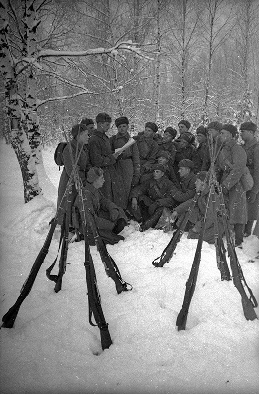 В зимнем лагере. Агитатор красноармеец Е. Андрияненко читает бойцам на привале газету, январь - февраль 1940