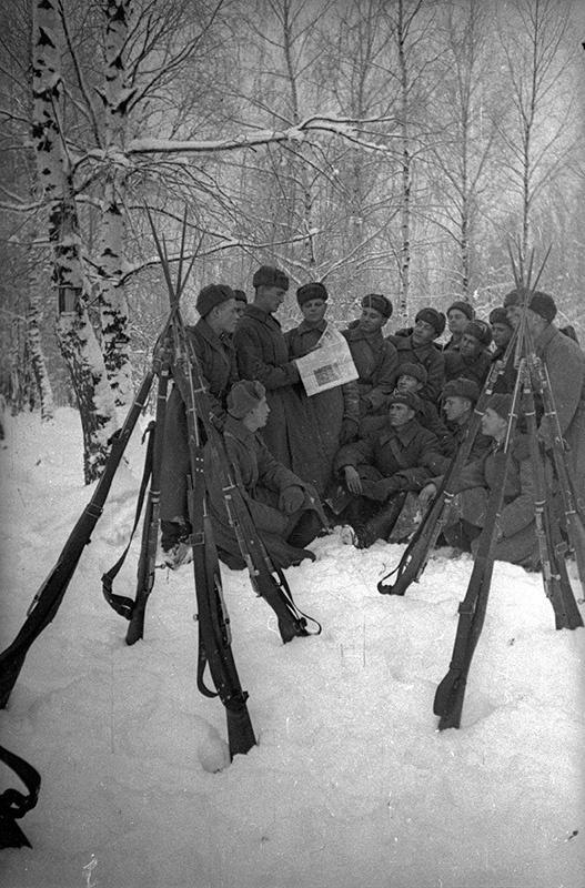 В зимнем лагере. Агитатор красноармеец Е. Андрияненко читает бойцам на привале газету, январь - февраль 1940