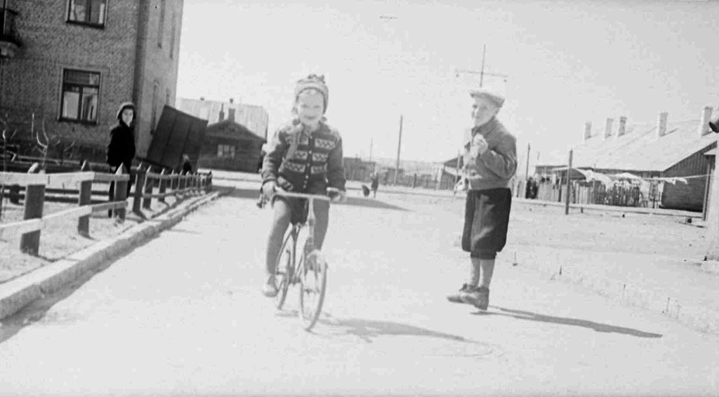 На велосипеде по улице, 1957 год, Московская обл., г. Люберцы. Выставка «Немного детства из небольшого городка 1950-х» с этой фотографией.