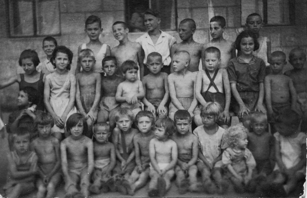Групповой портрет детей из дома 63 по улице Максима Горького, 1 мая 1945 - 31 октября 1947, г. Куйбышев. Дети из семей эвакуированных в Куйбышев, в основном, из Москвы. В первом ряду, шестая слева - Циля Милькина. Крайняя слева во втором ряду - Люся Федулова, рядом с ней (вторая слева) - Тамилла Никифорова, третья справа в этом же ряду - Маня Милькина, рядом (четвертый справа) - Алик Шарыпов. Второй слева в последнем ряду - Алик Никифоров.