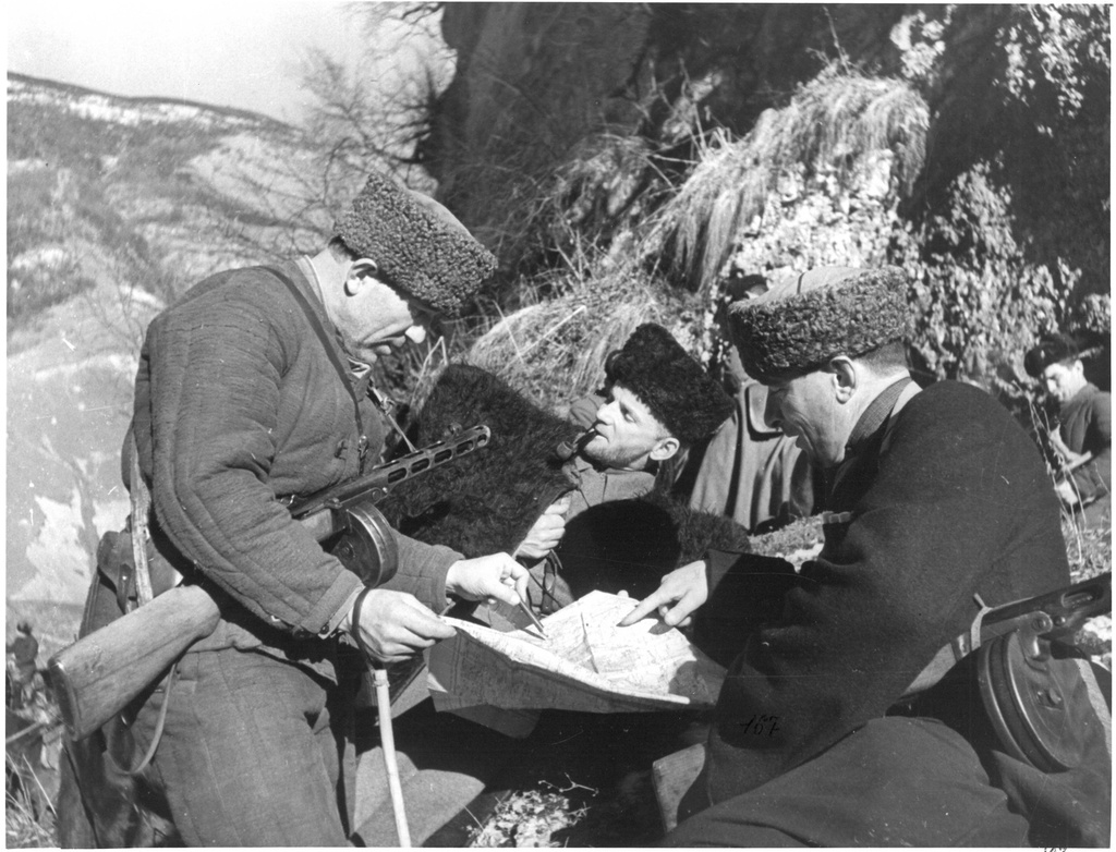 В партизанском отряде Мулухова уточняют задание, 1942 - 1943. Выставка «Хроника военных дней в фоторепортажах Виктора Темина» с этой фотографией.