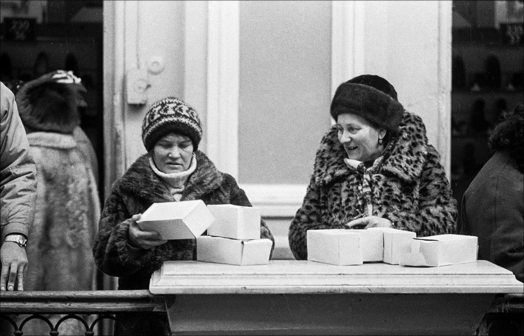 ГУМ. Женщины с коробками, 9 января 1990, г. Москва. Выставка «Игорь Стомахин. ГУМ в эпоху перемен» и видеовыставка «В центре ГУМа жизнь угрюма» с этой фотографией.