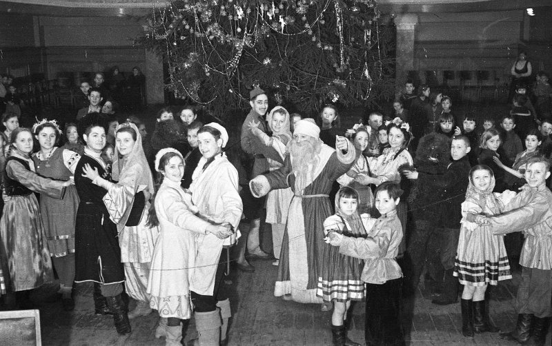 У Новогодней елки, 1940-е. Выставка «Снежинка, зайчик и мушкетер. Карнавальные костюмы на Новый год» с этим снимком.