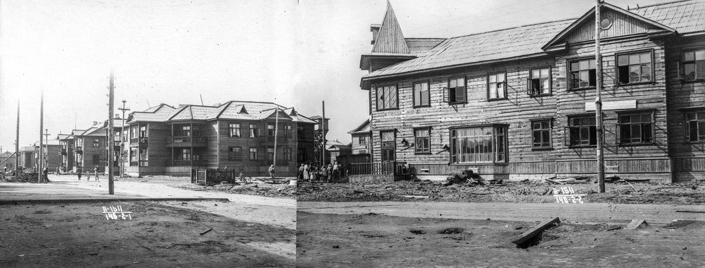 Общий вид кварталов, 13 июля 1940, Архангельская обл., г. Молотовск. Вид на северную часть Полярной улицы и перекресток с Советской. На улице Полярной построена широкая сланевая дорога. Справа – дом по Советской, 37. Большая витрина подсказывает, что на первом этаже здания расположен магазин. Улица Советская еще не благоустроена. На заднем плане – деревянный жилой дом с балконами на первом и втором этажах, большими балконами-верандами в угловой части.Город Молотовск в 1957 году переименован в Северодвинск. 