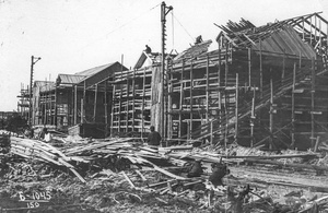 Строительство жилых домов на 4 участке, 22 июля 1939, Архангельская обл., г. Молотовск. Идет строительство двух деревянных двухэтажных жилых домов, окруженных строительными лесами и сходнями. Плотники покрывают тесом крышу ближнего дома. Перед домами возвышаются деревянные подъемные краны. Бригады рабочих разгружают пиломатериалы.Город Молотовск в 1957 году переименован в Северодвинск. 