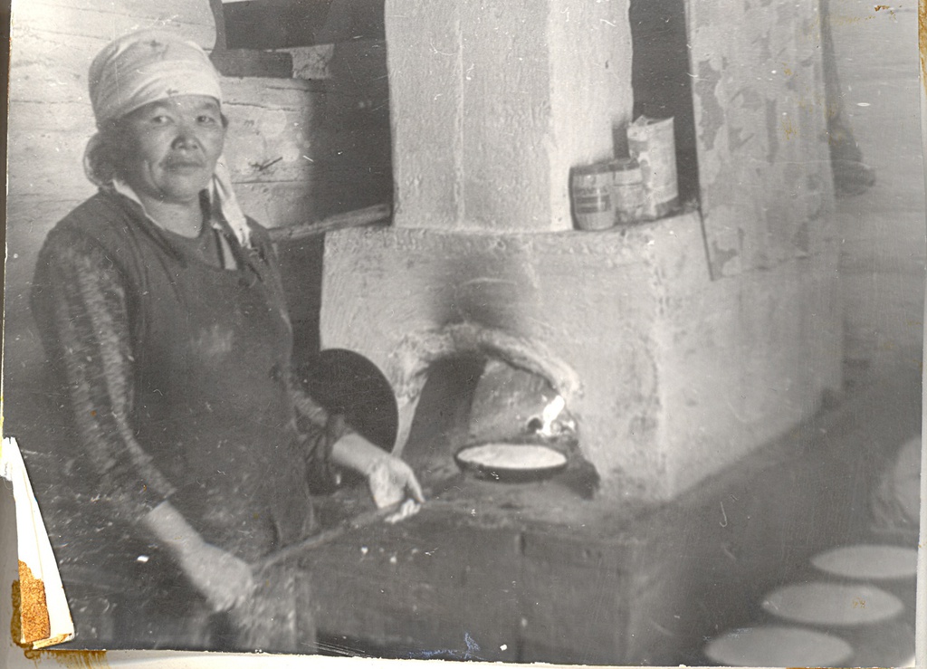 Шорка в печи выпекает хлеб, 1990 год, Кемеровская обл., Таштагольский р-н. Выставка «Жизнь шорских женщин» с этой фотографией.&nbsp;