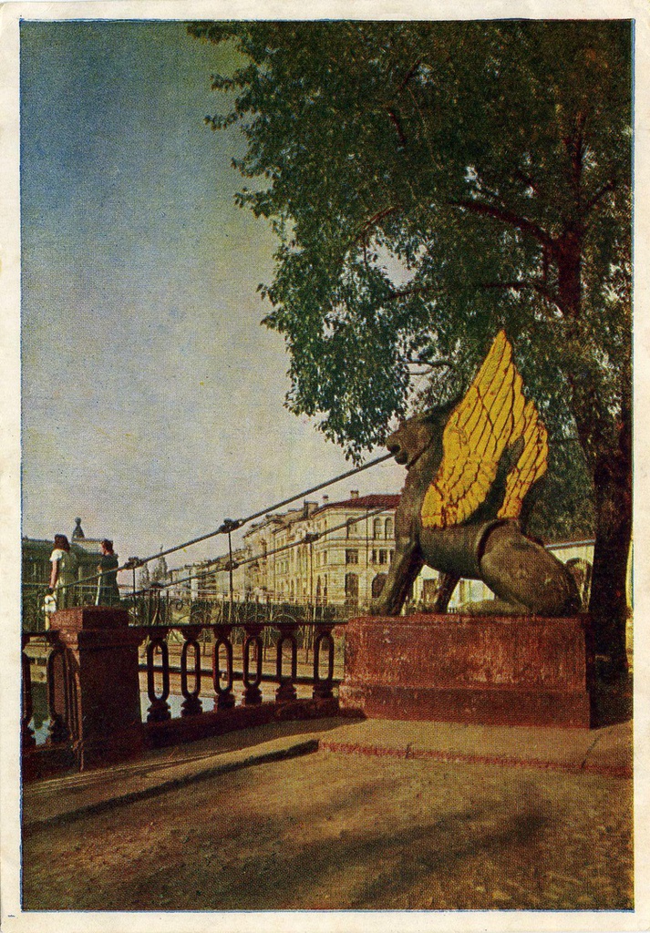 Банковский мостик, 1951 год, г. Ленинград. Банковский мост&nbsp;–&nbsp;выдающийся памятник архитектуры первой половины XIX века, созданный в замечательном содружестве немецкого инженера Вильгельма Треттера и Павла Соколова, признанного русского мастера декоративной классической скульптуры. Небольшой пешеходный мостик (по данным СПб ГБУ «Мостотрест»&nbsp;–общая длина 28 метров, ширина&nbsp;–&nbsp;3,1 метра), самый узкий в Северной столице (проходная часть между ограждениями составляет всего 1,8 метра)&nbsp;–&nbsp;один из немногих сохранившихся висячих цепных мостов. Мост был построен в 1826 году у входа в Ассигнационный банк и получил название&nbsp;–&nbsp;Банковский.&nbsp;Знаменитым его сделала скульптурная группа, состоящая из четырех крылатых львов.Почтовая открытка издательства&nbsp;«Росполиграфиздат», 1951 г, № А-00486.
