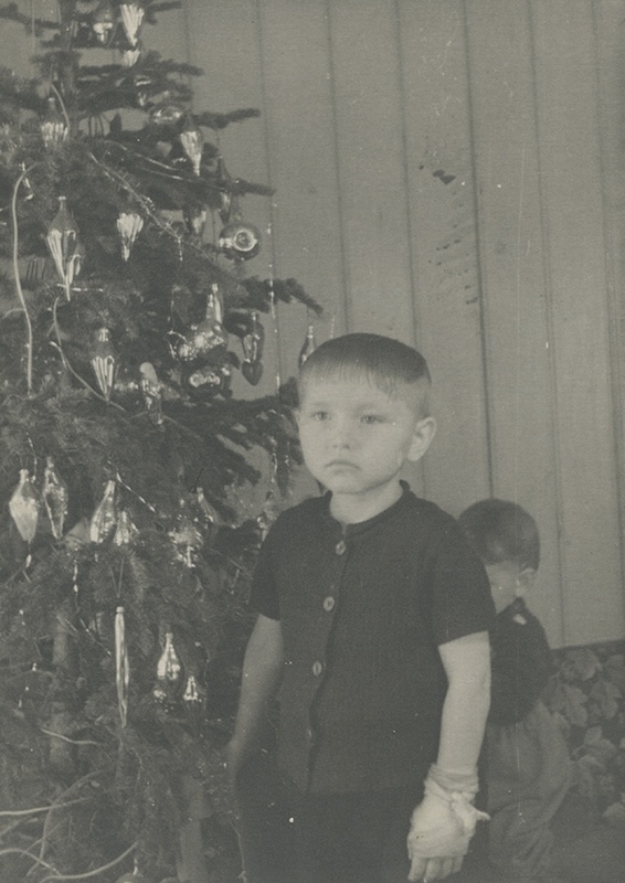 Лена у новогодней елки, 1960-е, Тюменская обл., Тобольский р-н, дер. Лутовинино. Волосы у Лены были жидкими, и ее мама верила, что если их стричь коротко, они наберут силу. Саша Лутовинин прячется за сестрой. На фото: Елена Степановна и Александр Степанович Лутовинины.