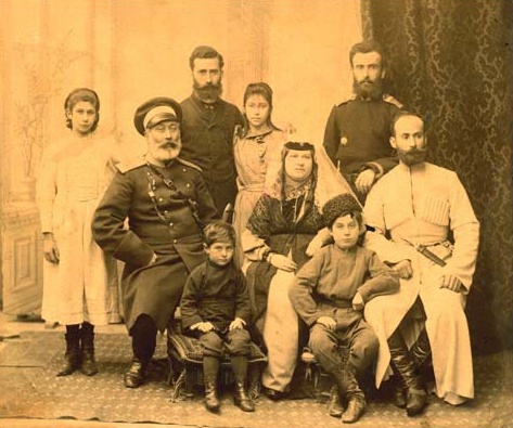 Семья Абуладзе, 1895 - 1900, Тифлисская губ., г. Тифлис. Семья фотографа Ильи Дариспановича Абуладзе (он стоит слева), один из пер­вых вла­дель­цев фо­то­ате­лье Те­мир-Хан-Шуры кон­ца XIX века. Его брат дворянин Симон Абуладзе (сидит справа), Пристав Темир-Хан-Шуринской городской полиции с 1911 года.