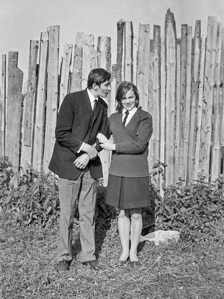 Двое возле забора, июнь 1970, Калининская обл., Старицкий р-н, д. Орешки. Александр Александрович Кружков проработал шофером более 40 лет в деревне Турково в Калининской, а затем в Тверской области. Все это время верными друзьями Александра Александровича были гармонь и фотокамера. В сельской глубинке владение этими вещами автоматически делало его первым парнем на деревне. Где с гармонью, как главное действующее лицо, где с фотокамерой, как внимательный летописец деревенских хроник, Александр Александрович принимал активнейшее участие в культурной жизни односельчан.  А событий в деревне хватало. Тут и свадьбы, и празднования дня Победы 9 мая, и сенокосы, и уборка картофеля, и день знаний 1-го сентября, и проводы в армию, и даже похороны…  Сейчас Александр Александрович уже не снимает. Пришла очередь детей и внуков. Лишь изредка берет в руки гармонь. Представлены серии снимков, сделанных Александром Александровичем в Калининской области с начала 70х годов до конца 90х годов прошлого века.