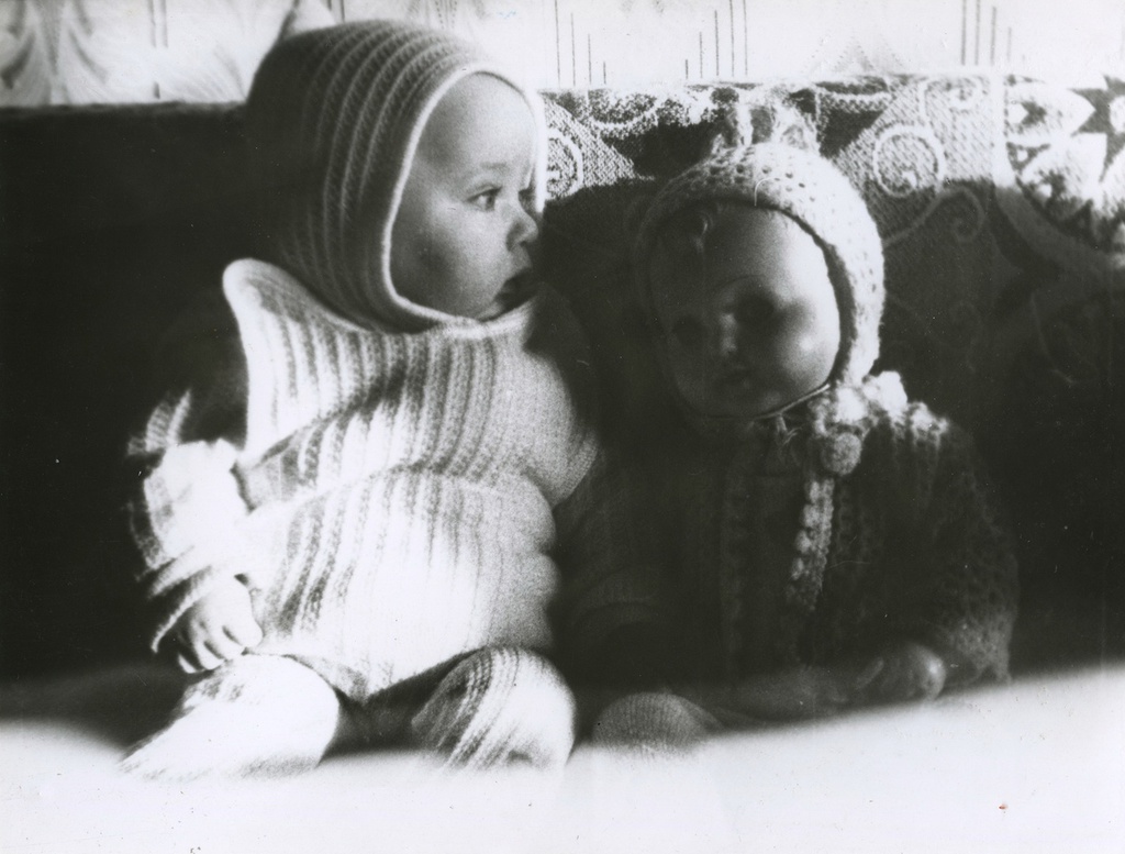 Младенец с куклой на диване, 1 февраля 1986, г. Москва. Вера Левченко. Надпись на обороте фотографии: «6 месяцев I/II-86».