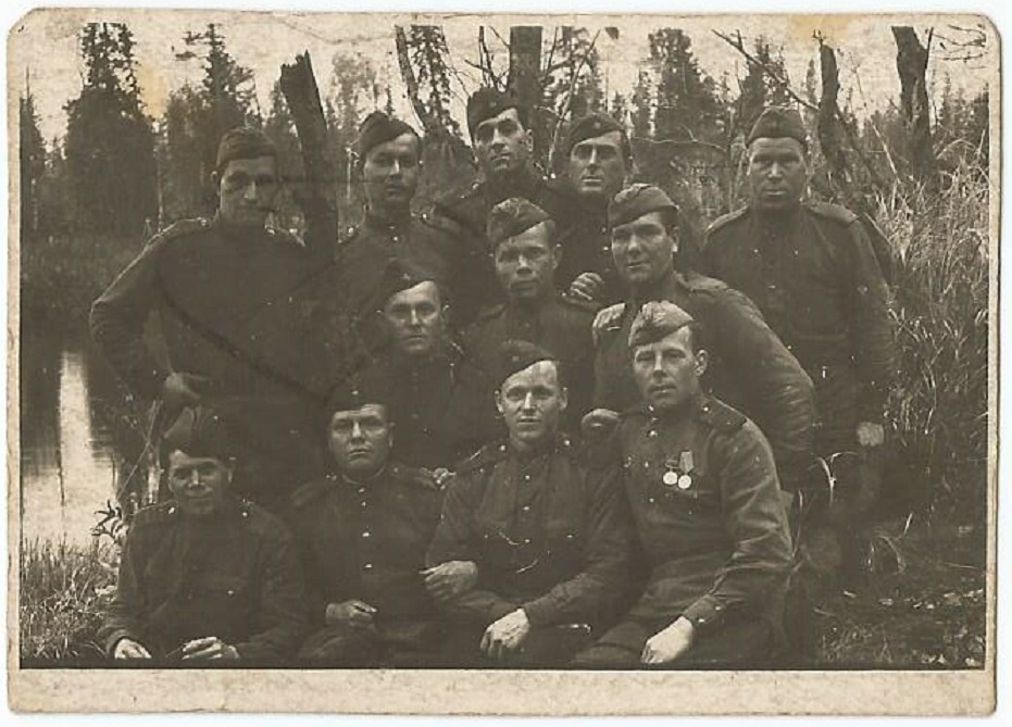 Бойцы Красной Армии, 1 июня 1943 - 31 мая 1945. Групповой снимок солдат и сержантов Красной армии, сделанный во второй половине Великой Отечественной войны. Среди бойцов выделяется младший сержант, сидящий справа в первом ряду. На его груди видны две медали – «За отвагу» с четырехугольной колодкой (медали данного типа вручались с 1938 по 1943 год), а также «За боевые заслуги» с пятиугольной колодкой, введенной в июне 1943 года.