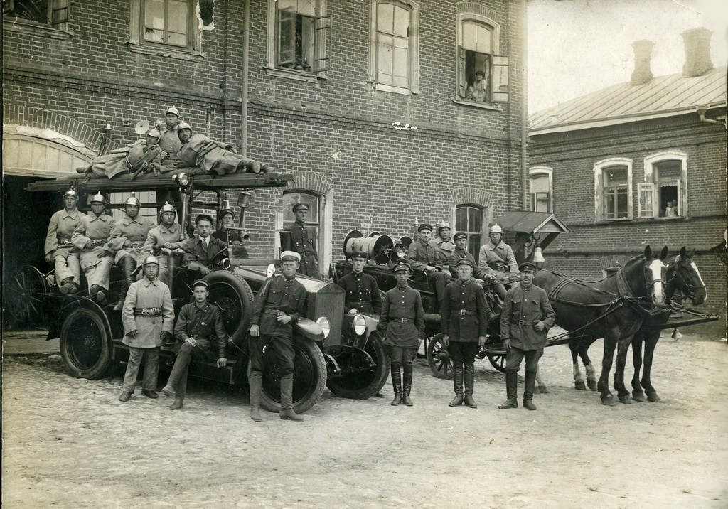Смотр пожарной дружины, 1930 год, Владимирская обл., г. Вязники. Второй справа – Иван Иванович Целоватов, рядом с ним крайний справа стоит его двоюродный брат – И. В. Целоватов, сидит на подножке автомобиля Борис Васильевич Борухсон, в белой фуражке облокотился на крыло машины начальник пожарного депо М. А. Солдатов.Фотография из архива Константина Целоватова, которую прислал Евгений Викторович Ахматов.