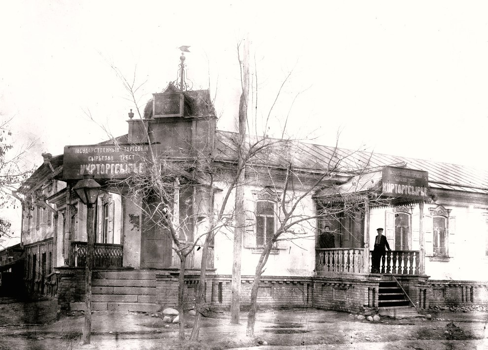 Купеческий дом в Пишпеке, 1925 - 1935, Киргизская АССР, г. Пишпек. Дом купца Василия Степановича Попова в городе Пишпеке на улице Береговой. На вывеске написано: «Государственный торговый сырьевой трест "Кирторгсырье"». Памятник архитектуры 2-й пол. XIX – нач. XX вв. (Пишпек – с 1878–1926 годы, с 1926–1991 годы – Фрунзе, с 1991 года – Бишкек). Ныне Бишкек – Кыргызская Республика.