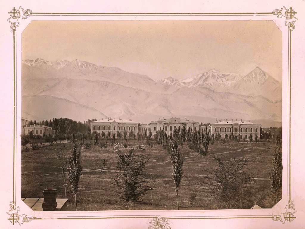 Мужская гимназия в городе Верном, 1883 - 1887, Семиреченская обл., Верненский у., г. Верный. Здание мужской гимназии в городе Верном на фоне хребта Заилийского Алатау (фотография сделана до верненского землетрясения 1887 года).  Верненская мужская гимназия была открыта в 1876 году. С 01.07.1881 года прогимназия получила статус полной классической гимназии, и с этого момента становится самым крупным учебным заведением города Верного с преподаванием древних языков – греческого и латинского, для поступления в вузы.