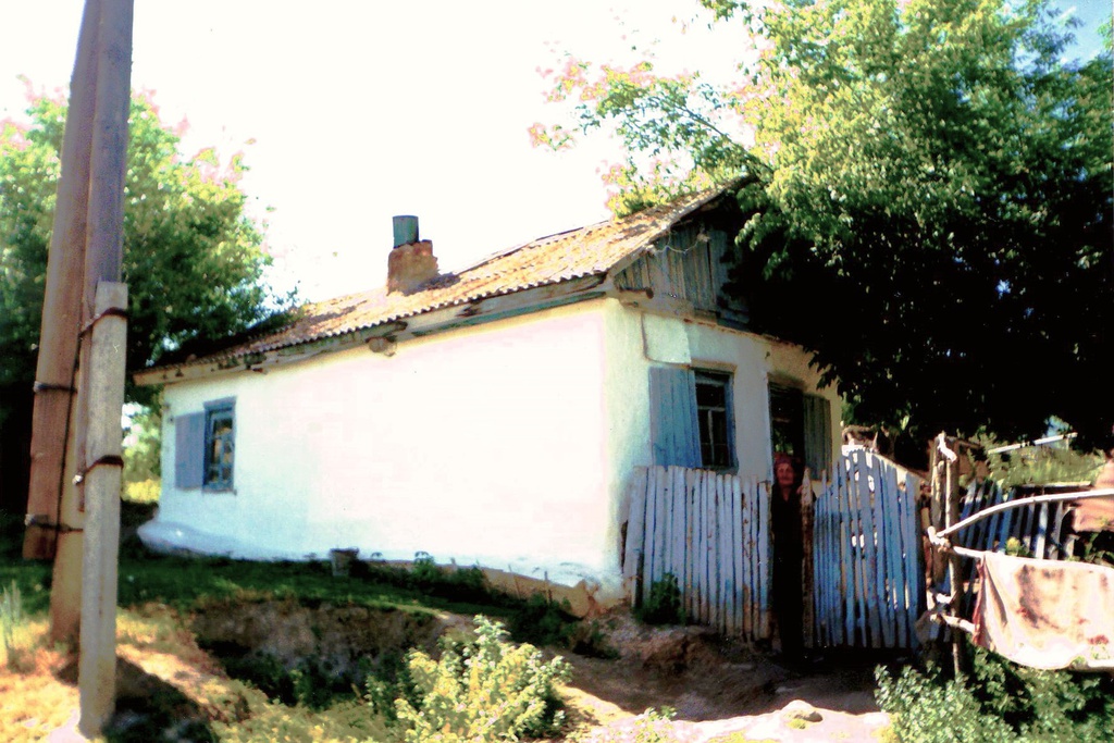 Дом капальской казачки Пелагеи Цыпленковой (Бутиной), 1990 год, Казахская ССР, Талды-Курганская обл., Капальский р-н, с. Капал. Дом потомственной казачки Пелагеи Степановны Цыпленковой, в девичестве Бутиной, находящийся на территории Капальской станицы.  П.С. Цыпленкова, как носитель казачьей культуры, в конце 1970-х гг. участвовала в опросе, проводимом фольклорной экспедицией из Алма-Аты, собиравшей и изучавшей фольклор семиреченских казаков.