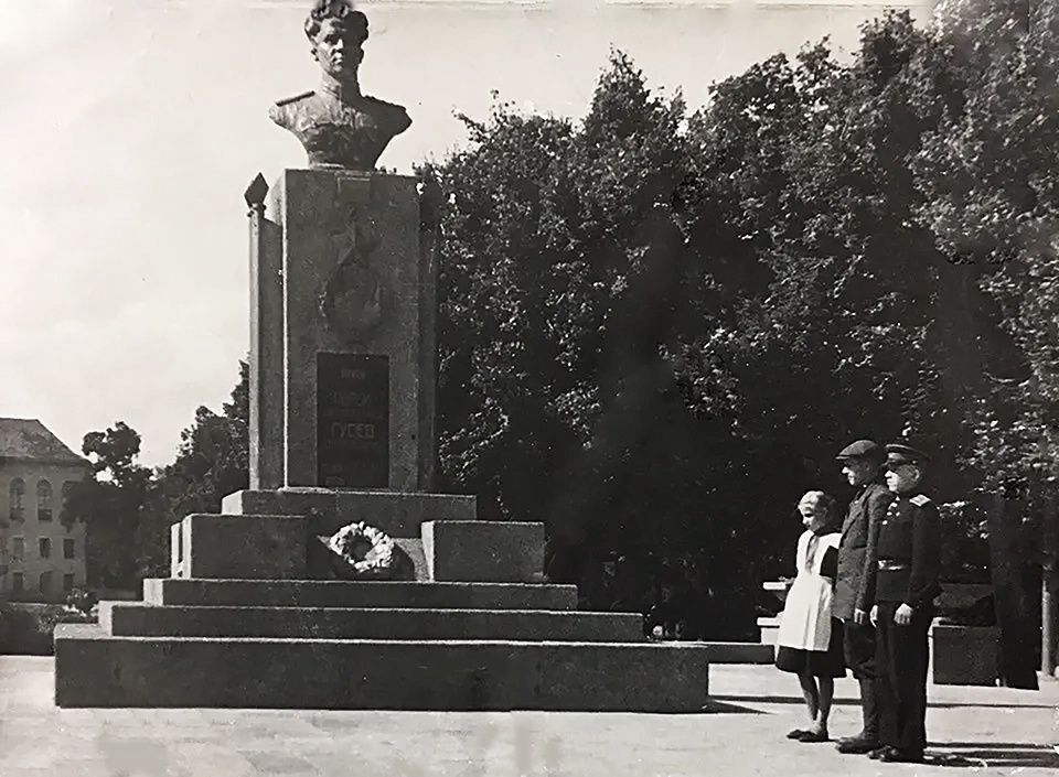 Семья Героя у памятника С. И. Гусеву, 1951 - 1953, Калининградская обл., г. Гусев. Семья С. И. Гусева – отец Героя, Иван Кузьмич Гусев, и дети Сергея Ивановича – сын Миша и дочь Нина, приехавшие издалека навестить своего сына и отца в бывший немецкий город Гумбиннен, в самом центре которого капитан Гусев и остался лежать навечно.