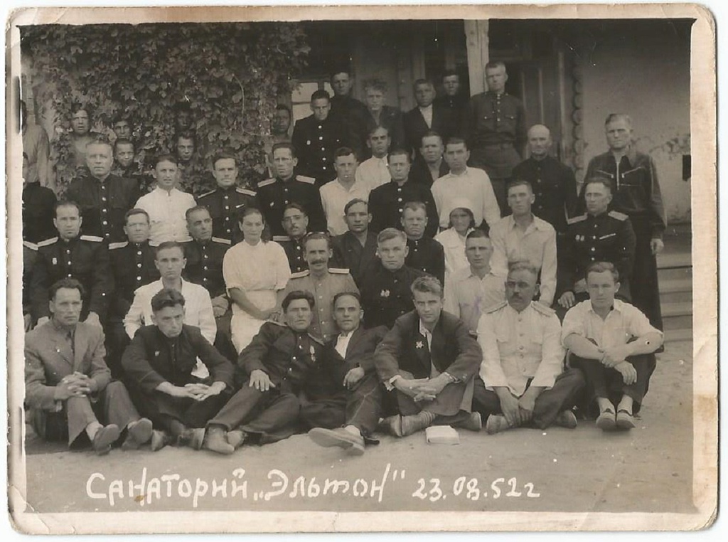 В санатории «Эльтон», 23 августа 1952, Сталинградская обл.. Групповая фотография людей в гражданской и форменной одежде. Большинство лиц в униформе на снимке являлись сотрудниками милиции. Они одеты в повседневную форму одежды образца 1947 года с повседневными кителями синего цвета. В первом ряду также виден сотрудник в летнем кителе белого цвета. Обращает на себя внимание наличие наград у некоторых героев снимка.Внизу фотокарточки имеется подпись: «Санаторий "Эльтон" 23.08.52 г.». С 1910 года на озере Эльтон (в настоящее время – Волгоградская область) находится грязевой и бальнеологический курорт. С 1945 года в 6 км к востоку от озера, в посёлке Эльтон функционирует одноименный санаторий.Подписи на обратной стороне снимка нет.