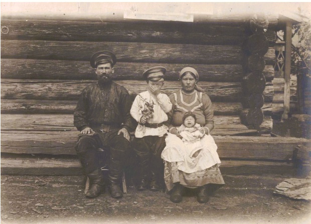 Семья у стены деревянного дома, 1913 год, Семиреченская обл., Верненский у., Казачья станица. Казачья семья у стены деревянного дома в семиреченской станице, предположительно, в Верненском уезде.