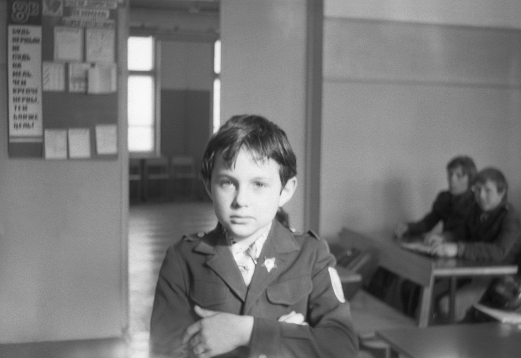 Школа № 301 в Свиблово, 8 класс «В», март 1977, г. Москва. Кабинет математики. Перемена. Второклассник Максим Михайловский – сын Людмилы Васильевны (классный руководитель 8 класса «В» и преподаватель математики). Позади виден холл на школьном этаже. Камера «Смена 8».