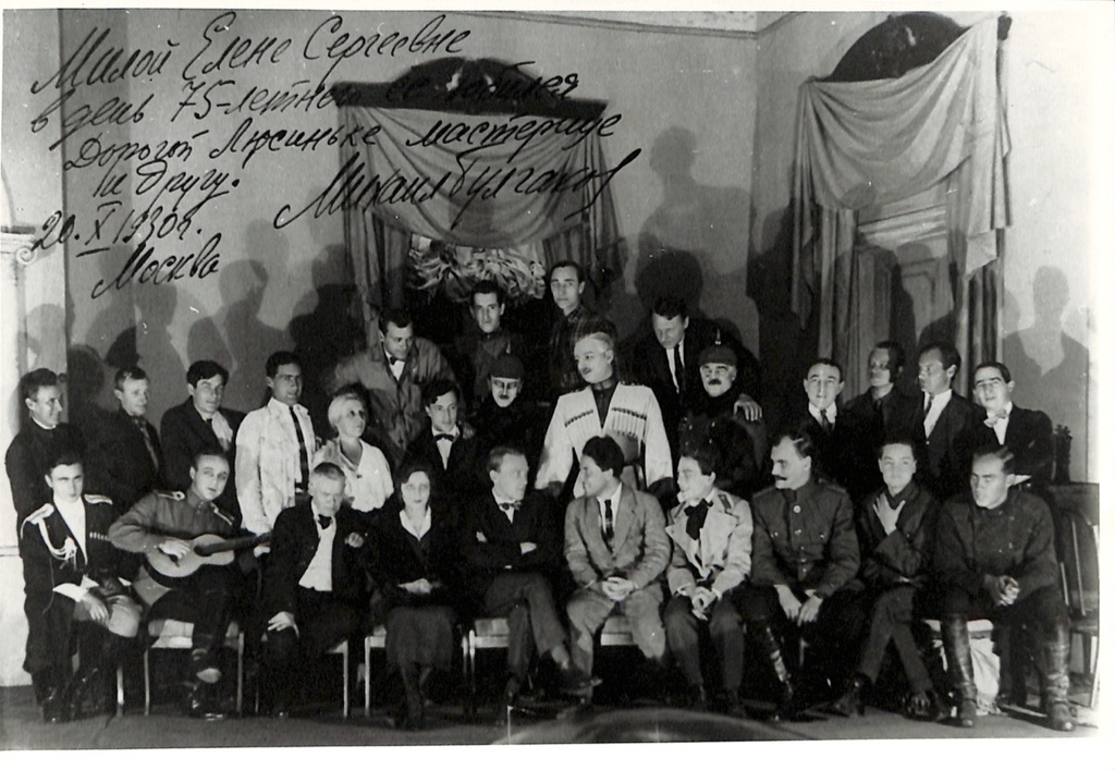 Михаил Афанасьевич Булгаков в группе актеров МХАТ, 22 сентября 1926, г. Москва. Пересъемка с фотографии с автографом Елене Сергеевне Шиловской от 20 октября 1930 года.Видеолекции&nbsp;«Шелковые носки, монокль и шапка из гризли: что предпочитал Михаил Булгаков»,&nbsp;«Терек, Пушкин, "Вероломный папаша": Михаил Булгаков во Владикавказе» и выставка «Михаил Булгаков» с этой фотографией.