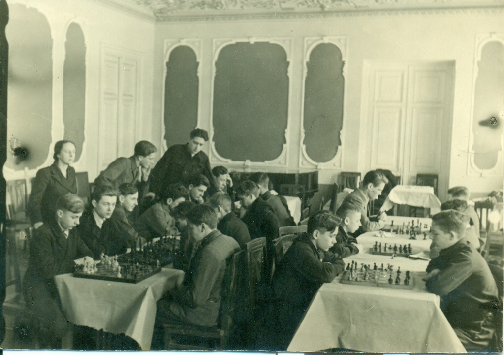 Шахматный кружок Дома пионеров Красногвардейского района Москвы, 1950 - 1960, г. Москва. Призер первых чемпионатов СССР по шахматам среди женщин Ольга Вячеславовна Морачевская руководит занятием шахматного кружка. Дом пионеров помещался во дворце Апраксиных-Трубецких у Покровских ворот.Фотография из архива Андрея Гришина.