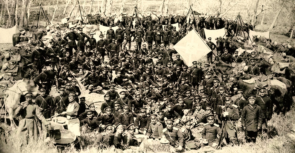 Бивуак 2-й сотни 1-го Сибирского казачьего Ермака Тимофеева полка близ Кульджи, 1880-е, Китайская империя, Илийский край, г. Кульджа. В 1880 году, ввиду осложнений в отношениях с Китаем, начался 2-й Кульджинский поход. 1-й Сибирский казачий Ермака Тимофеева полк занял город Кульджу и находился там до 7 марта 1883 года, затем, оставив в Кульдже 2 сотни, полк выступил в Джаркент. Служба 2-х сотен в Кульдже состояла в том, что они, поддерживая сообщения с Суйдунским, Мазарским и Яматинским отрядами, ещё выделяли и конвои к лицам уездной администрации на время их поездок по участку (ежедневный наряд доходил до 20 казаков).