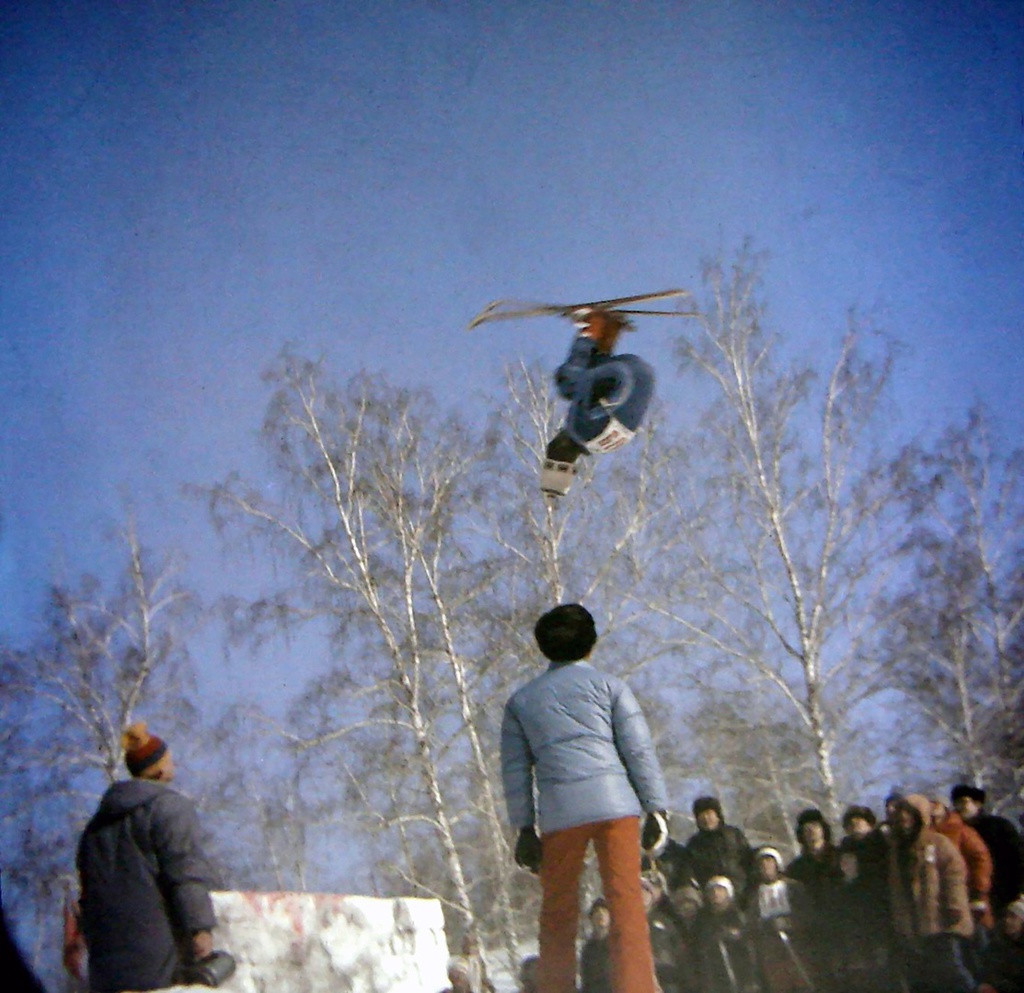 Лыжный фристайл в СССР 80-х годов ХХ века, 11 - 17 февраля 1985, г. Томск. Февраль 1985, город Томск, горнолыжный склон в районе 2-го переезда на южной окраине Томска. Первые открытые всесоюзные соревнования, организованные Российским советом «Буревестник» с участием спортсменов из России, Латвии, Украины и Узбекистана. Анатолий Чухломин выполняет двойное сальто назад в группировке на соревнованиях по лыжной акробатике.