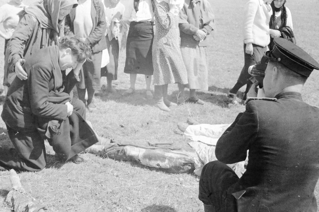 Эксгумация тел узников концлагеря «Красный», 21 - 23 апреля 1944, Крымская АССР, Симферопольский р-н, совхоз «Красный». Казненный в ночь с 10 на 11 апреля 1944 года Олег Саватеев (Савватеев) – ученик художника. Работал в  Симферопольском русском театре драмы (ныне – Крымский академический русский драматический театр имени М. Горького), член подпольной группы «Сокол», организованной главным художником театра Николаем Андреевичем Барышевым (1907–1944) и актрисой Александрой Федоровной Перегонец (1895–1944).  Из монтажного листа кинооператора: «Труп сына разыскал Саватеев Федор, его сыну Олегу 19 лет (отец Саватеев в черном плачет у трупа сына)».Выставка «Партизаны Крыма» с этой фотографией.