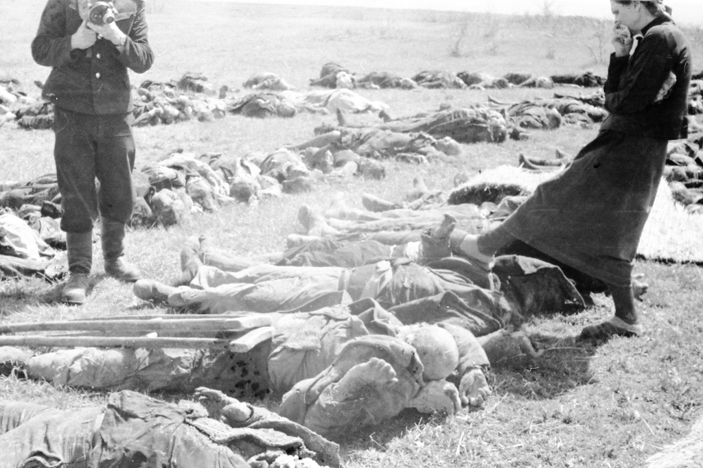 Эксгумация тел узников концлагеря «Красный», 21 - 23 апреля 1944, Крымская АССР, Симферопольский р-н, совхоз «Красный». Жители Симферополя и близлежащих сел разыскивают погибших родственников на месте эксгумации тел узников концлагеря «Красный» (находился на территории птицесовхоза «Красный» под Симферополем – место заключения советских военнопленных и гражданских лиц в период с ноября 1941 по апрель 1944 года). С кинокамерой военный корреспондент Иван Андреевич Запорожский.