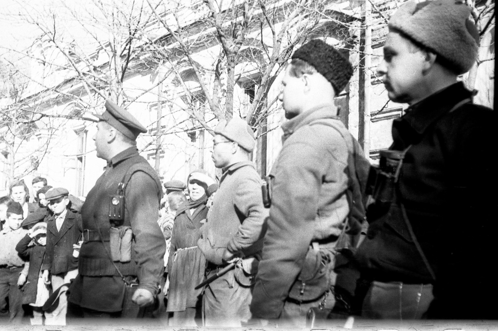 Партизаны Северного соединения в Симферополе. Парад партизан на улице Пушкинской, 13 апреля 1944, Крымская АССР, г. Симферополь. На первом плане (стоят справа налево): комиссар Николай Дмитриевич Луговой, командир 3-го партизанского отряда, капитан Федор Иванович Федоренко, комиссар 1-й бригады, редактор газеты «Красный Крым» Евгений Петрович Степанов, командир соединения Пинхус Рувимович (Петр Романович) Ямпольский.