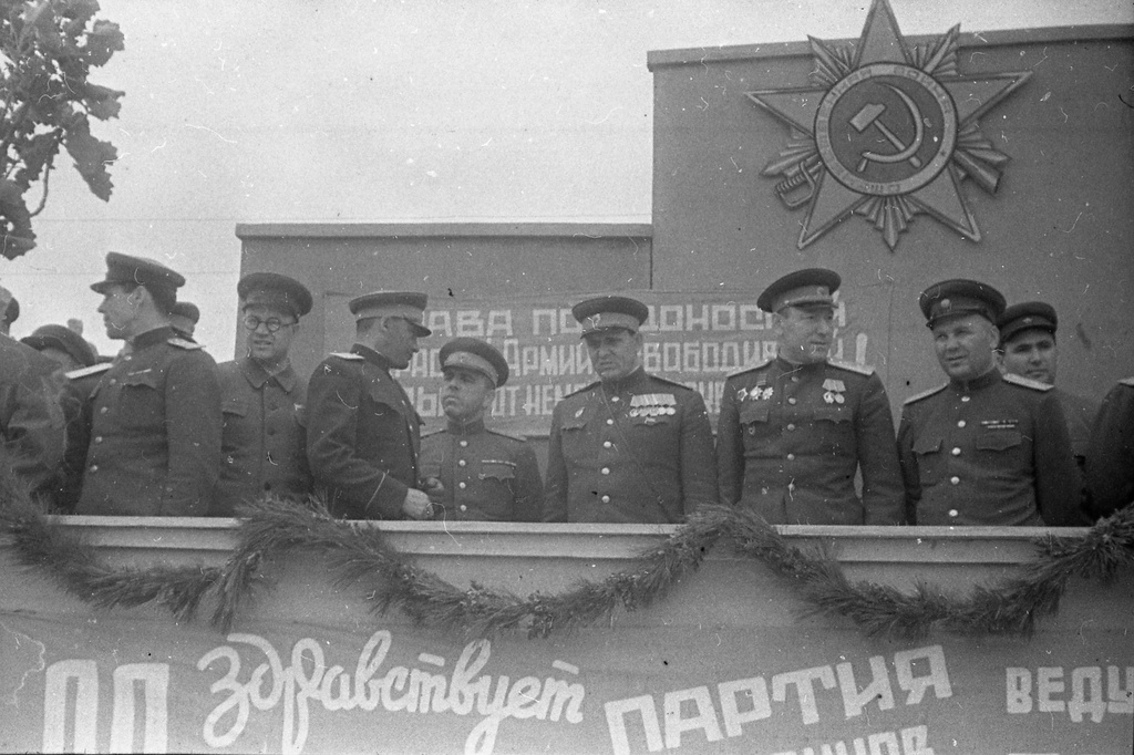 Митинг в освобожденном Симферополе, 14 апреля 1944, Крымская АССР, г. Симферополь. 14 апреля на Комсомольской площади Симферополя состоялся митинг жителей города и воинов-освободителей, на котором командующий 4-м Украинским фронтом генерал армии Федор Толбухин поздравил симферопольцев с освобождением. На трибуне командиры РККА (справа налево): командующий 2-й гвардейской армией, гвардии генерал-лейтенант Георгий Федорович Захаров, начальник штаба 4-го Украинского фронта, генерал-лейтенант Сергей Семенович Бирюзов, член военного совета 4-го Украинского фронта, генерал-лейтенант Никита Егорович Субботин; на втором плане (справа) командир Северного соединения партизан Крыма Павел Романович Ямпольский.Выставка «Партизаны Крыма» с этой фотографией.