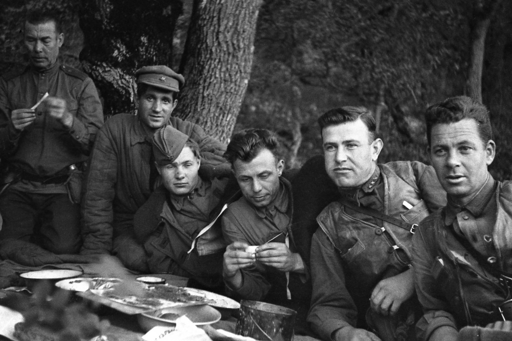 Партизаны Северного соединения Крыма, июнь - август 1943, Крымская АССР. Завтрак в расположении партизан (слева направо): неустановленное лицо, комиссар 1-й бригады Мирон Миронович Егоров, командир 1-й бригады Федор Иванович Федоренко, Петр Макарович Заболотный, нач. разведки 1-й бригады, старший лейтенант госбезопасности Павел Михайлович Рындин, партизан В. Бугаев.Выставка «Партизаны Крыма» с этой фотографией.