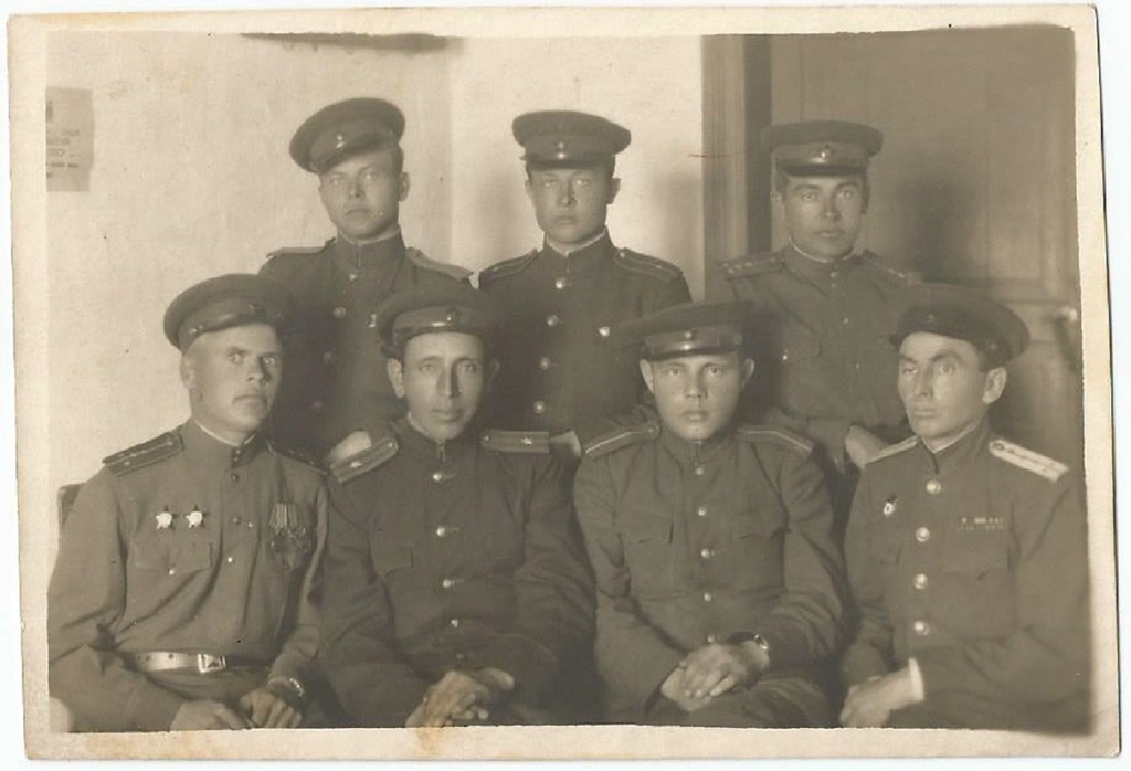 Товарищи офицеры, 1945 - 1949. Групповая фотография офицеров Красной армии в форме одежды образца 1943 года. Обращает на себя внимание то, что часть командиров одета в полевую форму одежды (гимнастерка, погоны защитного цвета), другие офицеры носят повседневный китель, но с полевыми погонами.Гвардии капитан медицинской (или ветеринарной) службы (крайний справа в первом ряду) единственный, кто носит повседневные погоны. В данном случае, это «узкие» погоны с серебристым галуном, установленные для офицеров-медиков (а также ветеринаров, юристов, и административной службы). Эмблемы медицинской и ветеринарной служб Красной армии имели одинаковый рисунок (чашу со змеей), но отличались цветом. Эмблемы медиков были золотистыми, ветеринаров – серебристыми.Также стоит отметить, что капитан носит вместо орденов и медалей соответствующие ленты на планках.Сидящий слева в первом ряду – капитан выделяется наличием нескольких наград – двух орденов Красной Звезды и тремя медалями.Младший лейтенант, стоящий в центре второго ряда, носит значок члена КИМ (Коммунистического интернационала молодежи) или значок члена ВЛКСМ образца 1945 года. Оба этих знака имели одинаковый дизайн и отличались только надписью, которую по данной фотографии определить не представляется возможным.Подписи на обратной стороне снимка нет.