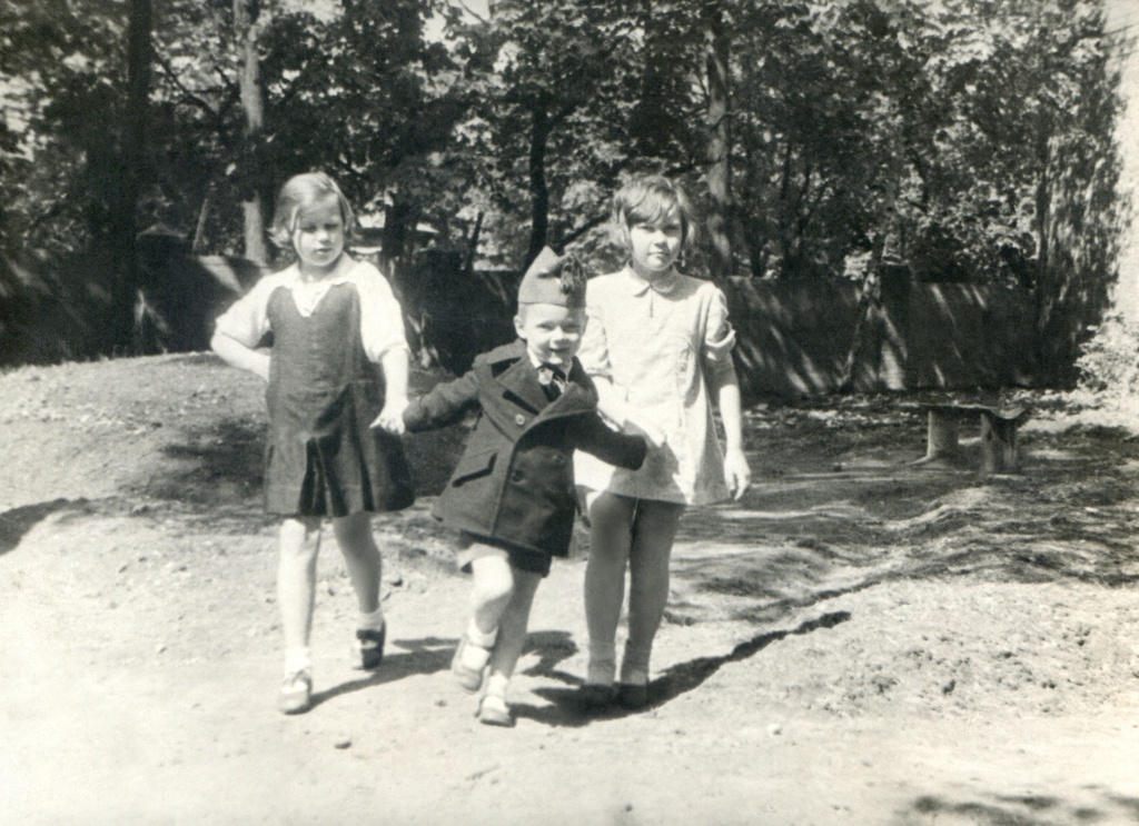 Портрет сына и соседских девочек во дворе дома 10 на Житной улице, 1936 год, г. Москва. Сын автора под присмотром соседских девочек. Позади детей – забор и клумба. Автор – Борис Александрович Баш (Шишлянников) (1901–1942), фотограф, кинооператор и режиссер.