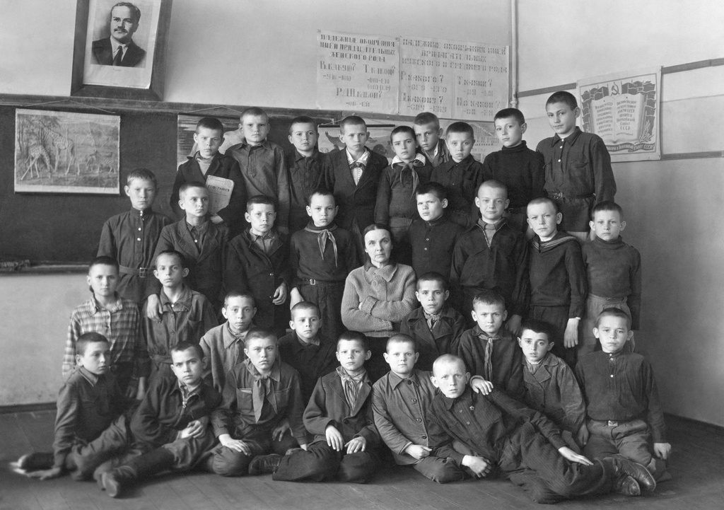 Мужская школа № 569 Москворецкого района, 5 класс «Б», 1945 - 1946, г. Москва. Олег Борисович Баш (13-14 лет) стоит третий справа во 2-м ряду сверху, в это время он проживал в Нижних Котлах.Фото подписано рукой Олега (в 40-х годах). Слева направо, с верхнего ряда:1) Шапаев, Скобелев, Морковин, Сычёв, Робинович, Гучнин, Блинков, Христолюбов, Есеновский.2) Тюрин, Качурин, Лисаков, Рыжов, Утешев, Баш, Серюгин, Радаев.3) Насонов, Ларцев, Киреев, Кудрявцев, Грибенников, Марков, Короткий, Саламатин, Корсаков, Михайлов, Фролов, Сидоров, Новиков, Болясов.Преподаватель Зинаида Константиновна Брэкстэт.Летом 1941 года, после окончания 1-го класса в школе № 548 и начала войны, Олег с мамой уехал в Омск в эвакуацию, где и закончил 2-й класс в 1942 году. Осенью 1943 года Олег с мамой вернулся из эвакуации в Москву и пошёл в 3-й класс «Б» мужской школы № 569, пропустив 1-ю четверть обучения. В 1946 году Олег Борисович Баш закончил 5-й класс «Б» мужской школы № 569 и осенью этого года поступил в Ремесленное училище № 57.Примечание владельца архива:1) Фамилия преподавателя, вероятно, Брекстедт.2) Портрет на стене: Вячеслав Михайлович Молотов, председатель Совета народных комиссаров СССР в 1930–1941 годах.